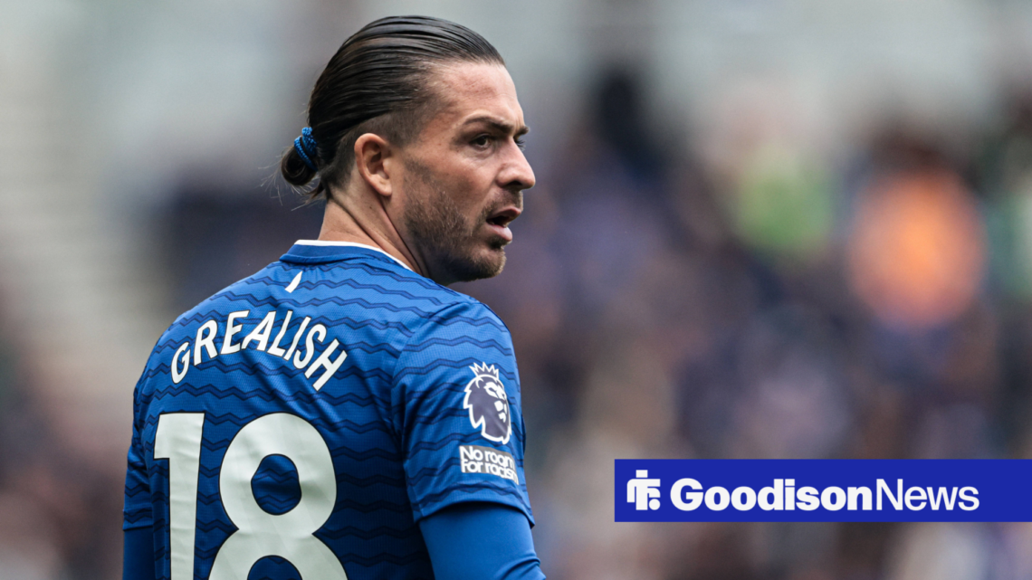 Jack Grealish in an Everton kit with his back to the viewer. He looks annoyed.