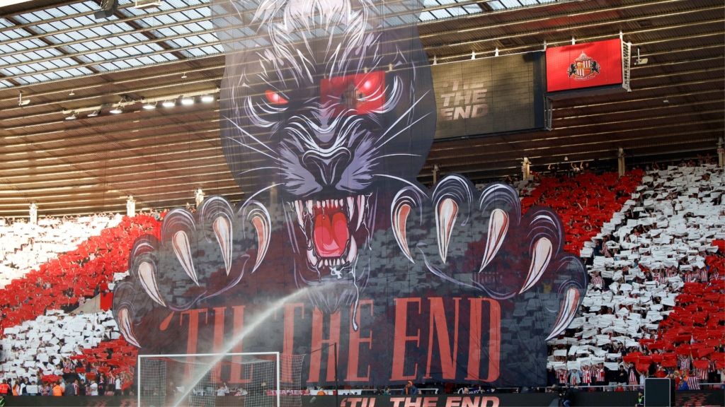 Sunderland fans hold up a tifo of a black cat at the Stadium of Light.
