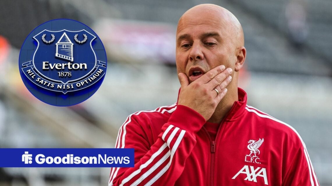 Arne Slot wearing Liverpool gear, looking baffled in the direction of the Everton crest.