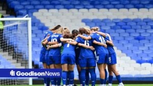 Everton women in a team huddle.